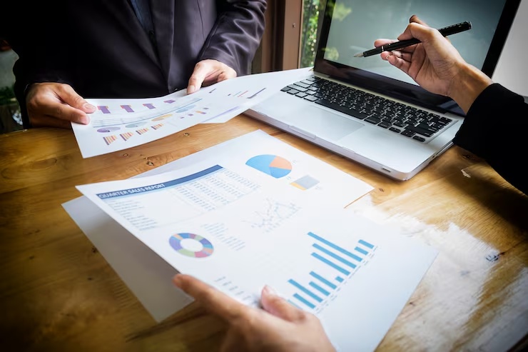 Profissionais analisando relatórios e indicadores financeiros em reunião